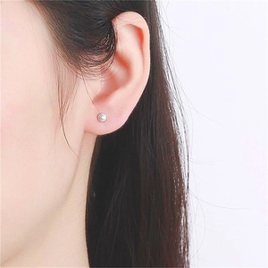 Close-up of a minimalist S925 sterling silver barbell stud earring on a model ear