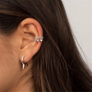 Detail of silver irregular ear cuff and hoop earring set with zircon charms on ear