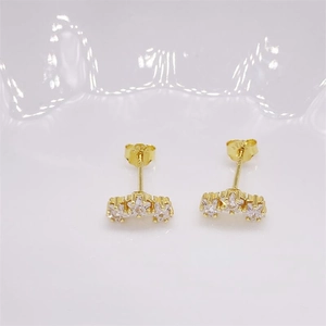 Macro detail of gold plated S925 silver stud earrings with three sparkling round zircons