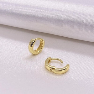 Boucles d'oreilles Huggie minimalistes en argent S925 doré sur fond en soie blanche