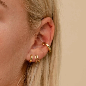 Gros plan d'un ensemble de boucles d'oreilles et bagues d'oreille en argent S925 doré poli