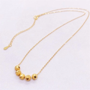 Detailed view of five frosted gold beads on a delicate S925 silver chain necklace