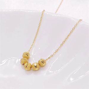 Detailed close-up of five golden beads with glittering texture on a fine S925 silver chain