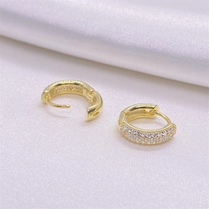 Macro shot of S925 sterling silver hoop earrings with pavé cubic zirconia on white silk