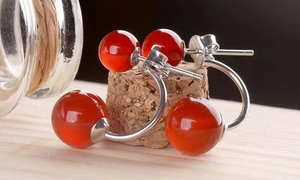 Macro shot of S925 sterling silver stamp on red agate stud earrings with cork background