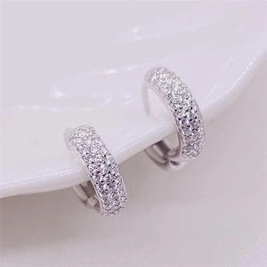 Close-up of sparkling pavé-set cubic zirconia on polished silver hoop earrings