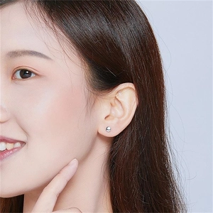 Minimalist S925 sterling silver round stud earrings worn by a model in a close-up shot