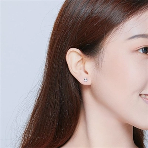 Minimalist S925 sterling silver round stud earrings shown on a female model ear lobe