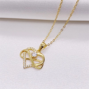 Detail view of gold heart pendant with sparkling pavé crystals and central zircon stone