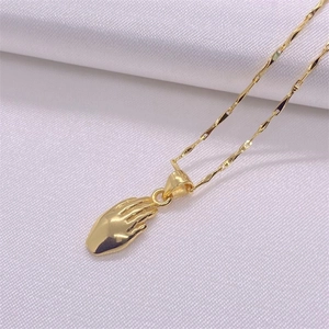 Dettaglio di una collana con pendente a palma in argento S925 dorato su seta