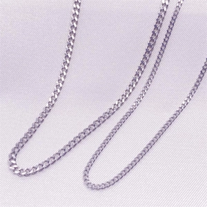 Macro shot of polished S925 sterling silver curb chain on soft purple fabric