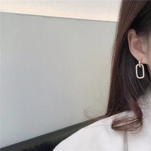Close-up of elegant gold S925 silver earrings with pavé crystals on a female model