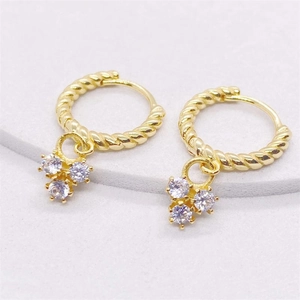 Detailed macro view of S925 silver twist hoop earrings with 18K gold finish and cubic zirconia