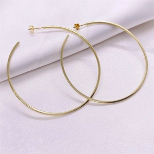 Minimalist large golden S925 sterling silver hoop earrings on elegant white silk fabric