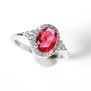Close-up of S925 sterling silver ring with oval red zircon and halo diamond setting