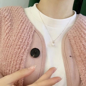 Close-up of minimalist S925 silver pearl pendant necklace worn on a woman's neck