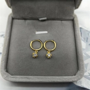 Close-up of gold S925 sterling silver hoop earrings with cubic zirconia cube pendants