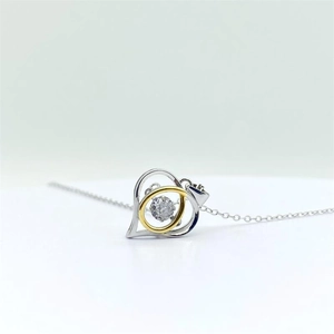 Macro shot of S925 sterling silver heart pendant with two-tone gold ring and crystal