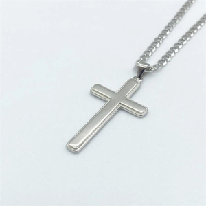 Gros plan du pendentif croix en argent poli avec bords multicouches sur chaîne fine