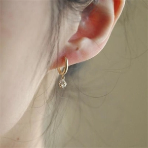 Close-up of gold cubic zirconia cube drop earrings on model for an elegant daily look