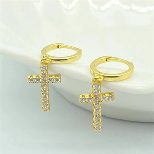 Vue détaillée de boucles d'oreilles créoles croix dorées serties de zircones