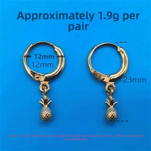 Detailed view of gold pineapple hoop earrings with engraved texture on a blue background