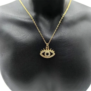 Dettaglio della collana con ciondolo occhio del diavolo oro e pietra blu su busto