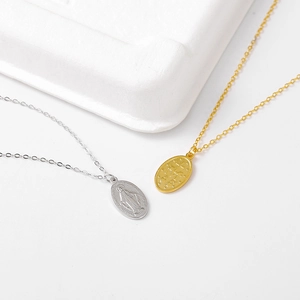 Detailed macro view of S925 silver and gold Virgin Mary oval religious medal necklaces