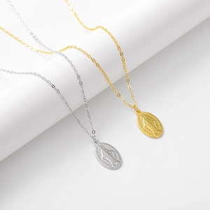 Detailed close-up of S925 sterling silver Virgin Mary oval pendants in gold and silver