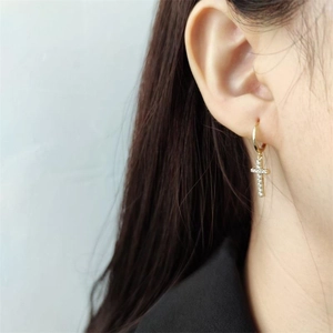 Gros plan de boucles d'oreilles croix en argent 925 doré avec cristaux brillants