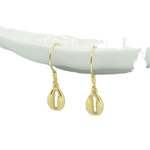 Golden seashell drop earrings in S925 sterling silver hanging on white ceramic