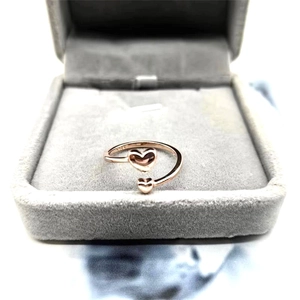 Macro detail of rose gold double heart open ring showing the S925 silver hallmark
