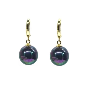 Vue macro de boucles d'oreilles dorées avec perles irisées violet foncé et vert