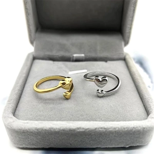 Detailed shot of gold and silver S925 heart rings showing the hallmarks and open band