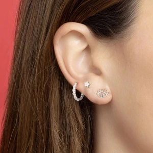 Vue macro de créoles torsadées et boucles d'oreilles étoile en argent S925