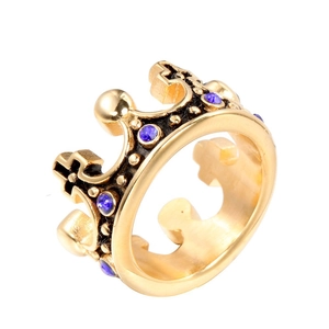 Bague couronne dorée vintage avec cristaux bleus et détails de croix sur fond blanc