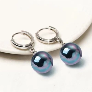 Vue macro des boucles d'oreilles en argent S925 avec des perles noires irisées
