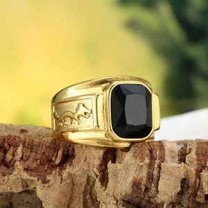 Macro shot of titanium steel ring with black rectangular gemstone and dragon carving