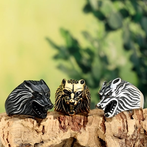 Relief détaillé de bagues tête de loup en noir, or et argent sur un support en bois