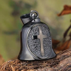 Retro black viking cross bell pendant in stainless steel displayed on rustic bark