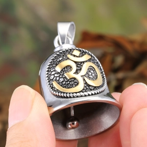 Close-up of vintage bell pendant with golden Om symbol and rustic silver metal finish