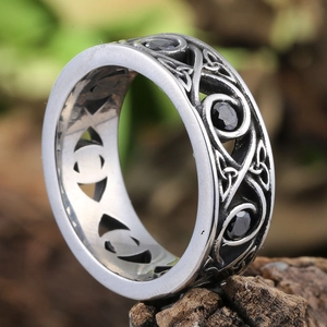 Macro shot of retro stainless steel ring with Celtic knots and black stone inlays
