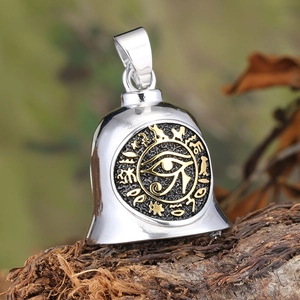 Detail of Eye of Horus bell pendant in silver and gold steel on a tree bark base