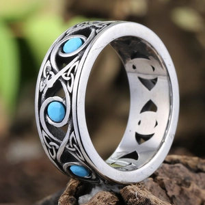 Macro detail of silver stainless steel ring with Celtic knot and blue turquoise stones