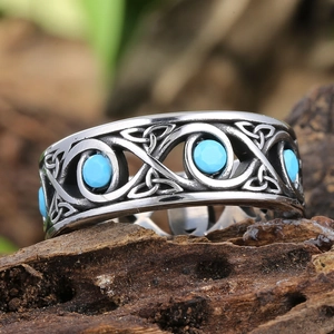 Macro shot of retro stainless steel ring featuring Celtic knots and blue turquoise stones