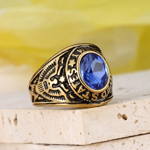 Macro shot of gold US Army eagle ring with faceted oval blue stone on stone base