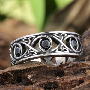 Macro detail of vintage stainless steel Celtic knot ring with black gemstones
