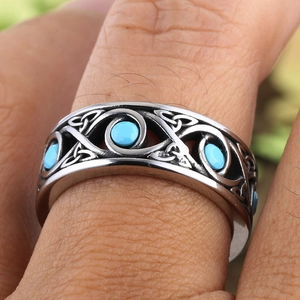 Macro detail of men's vintage steel ring with Celtic knots and turquoise inlay