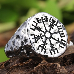 Macro shot of vintage Viking Vegvisir compass ring with hammered texture on wood