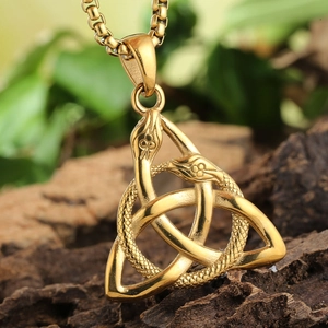 Close-up of gold Viking snake pendant with Celtic knot on rustic tree bark